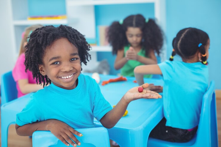 smiling-kids-using-modelling-clay_13339-174006